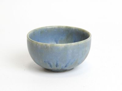 a small blue bowl sitting on a white surface