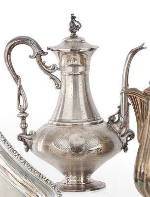 une cafetière en argent posée à côté d'un pichet en argent