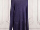the purple sweater is on a mannequin stand in front of a white wall