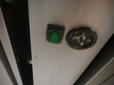 a close up of a green button on a metal door
