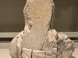a stone sculpture of a person sitting on a bench