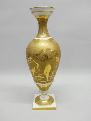 un vase doré posé sur une table blanche