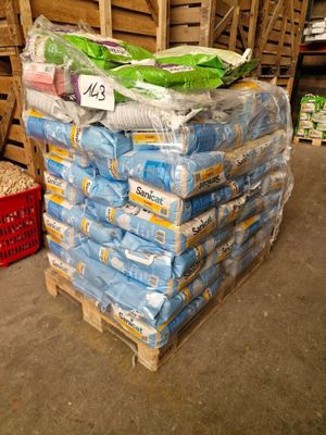 many bags of rice sitting on a pallet in a warehouse