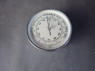 une horloge posée sur une table, sur fond noir