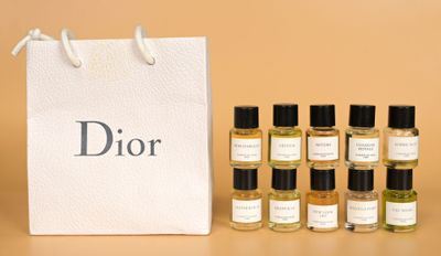 six flacons de parfum Dior devant un sac blanc