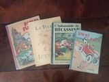 four children ' s books are lined up on a wooden table