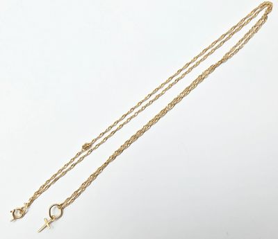 a close up of a gold necklace with a cross on it