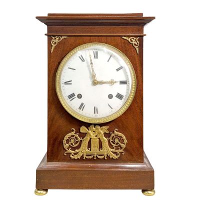 une horloge en bois exposée sur un fond blanc