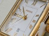 a gold watch with roman numerals on the face of it