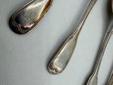 three spoons and two spoons sitting on a table