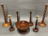 several wooden candlesticks and a bowl on a table
