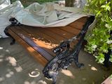 a wooden bench with a sheet on it in the shade
