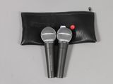 two microphones in a black pouch on a white surface