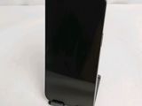the back of a black cell phone sitting on top of a white table