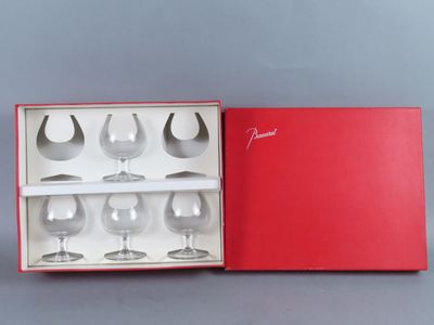 quatre verres à vin dans une boîte rouge posée sur la table