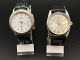 Deux montres sont posées côte à côte sur une surface noire.