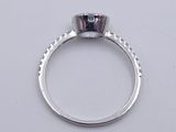 a close up of a diamond ring on a white surface