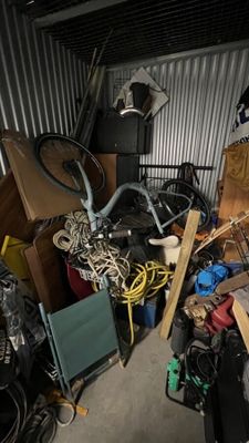 a pile of junk in a garage with a bike in it