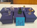 purple boxes with glass figurines on top of them on a table