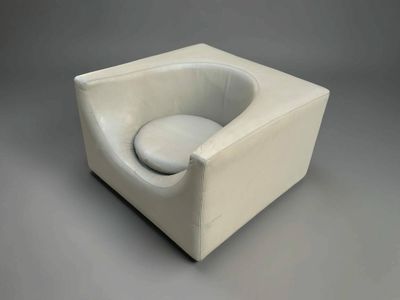 une chaise blanche sur laquelle est posé un coussin blanc