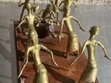 figurines en laiton représentant un groupe de danseurs, posées sur un socle en bois