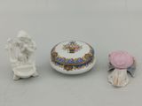 trois petites figurines assises les unes à côté des autres sur une table
