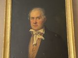 portrait d'un homme en costume et nœud papillon dans un cadre doré
