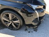 a black car that has a dent in the front of it