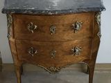 a marble top chest of drawers in the corner of a room