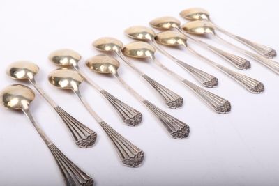 a set of six silverplated spoons on a white surface
