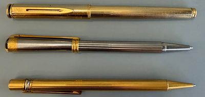 Trois types de stylos différents sont alignés sur une table
