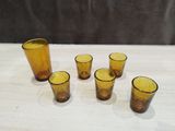 yellow glass shot glasses sitting on top of a table next to each other