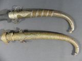 two very long horn shaped knives on a table