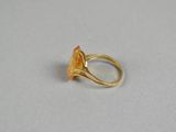 a close up of a gold ring on a white surface