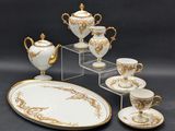 a white and gold table setting with a tray and cups