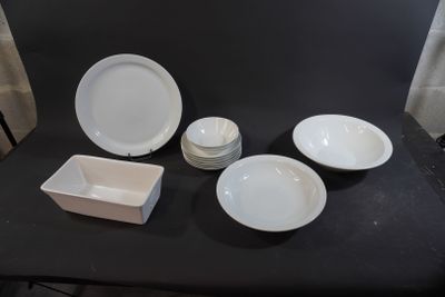 a black table with white plates and bowls on it