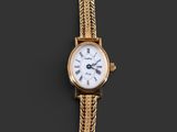 une montre-bracelet en or avec un cadran blanc et une chaîne en or