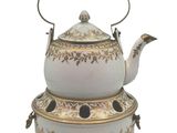 a white tea pot with a gold decoration on it