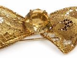 golden bow brooch with a golden crystal center