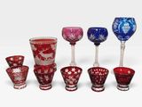 a group of different colored glass vases on a white surface
