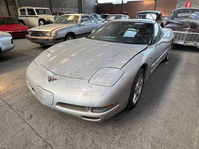 a silver car parked in a garage next to other cars