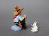 a small figurine of a cowboy and a dog