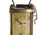 une petite horloge en laiton avec une corde autour de la poignée