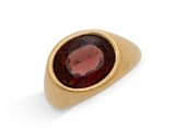 gros plan d'une bague en or avec une pierre rouge