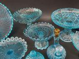 several pieces of blue glass are arranged on a black surface