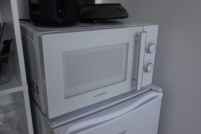 two microwaves stacked on top of each other in a kitchen