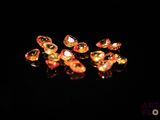 several pieces of gold colored glass sitting on top of a black surface