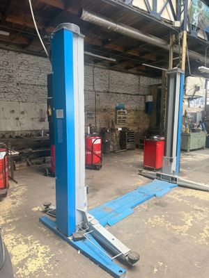 a couple of blue lifts sitting in a garage next to a building