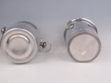 pair of silver plated teapots on a white background