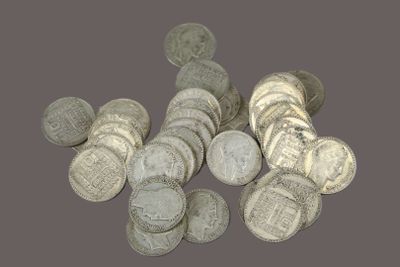 pile of silver coins on a gray background